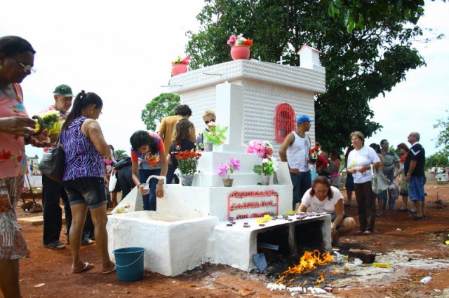 Fiéis colocam velas, flores e bebem água de túmulo (Foto: Marcos Ermínio)