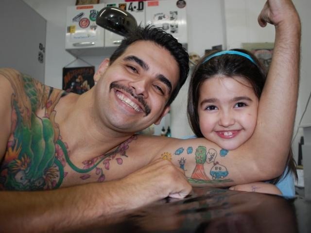Pai e filha em dia de sessão no tatuador.