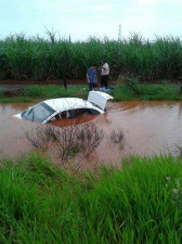 Veículo saiu da pista e caiu em lagoa formada pela chuva. Vereadores saíram pelo vidro traseiro do veículo. (Foto: Laguna Informa)