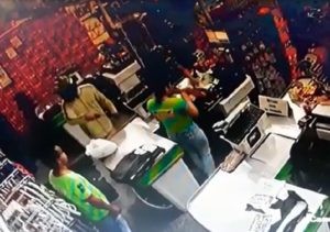 Dois indivíduos, com capacetes, entraram no supermercado e assaltam o caixa.
