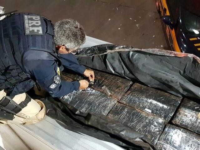 Droga sendo descarregada do caminhão. (Foto: Divulgação / Polícia Rodoviário Federal/ReproduçãoG1)