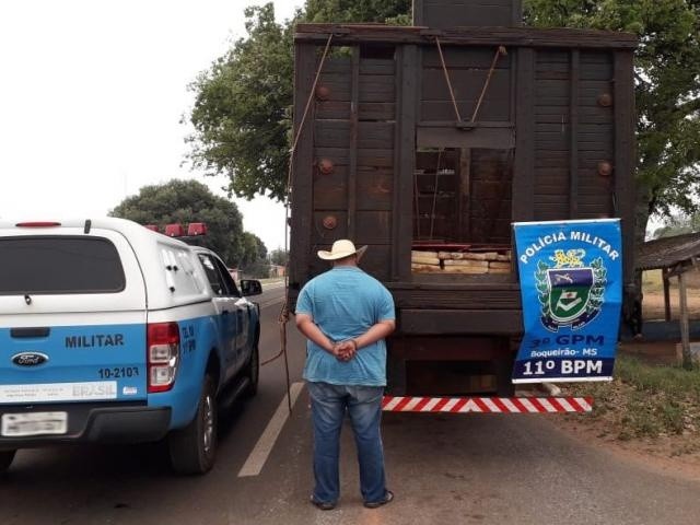 Motorista ao lado do caminhão onde foram encontrados os tabletes da droga. (Foto: Divulgação/PM)