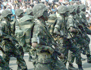 Homens do Exército, com rostos pintados e roupas próprias para serem usadas na mata fechadaBruna Girotto